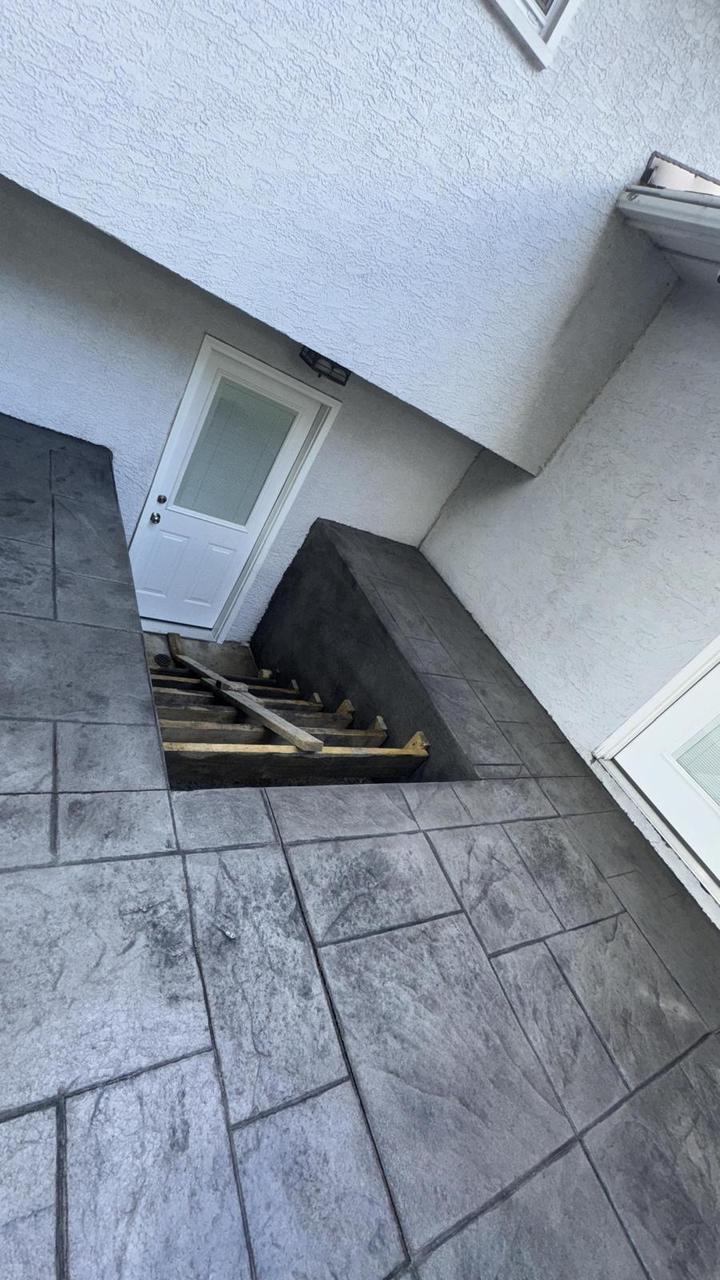 Stamped concrete landing beside a basement stairwell