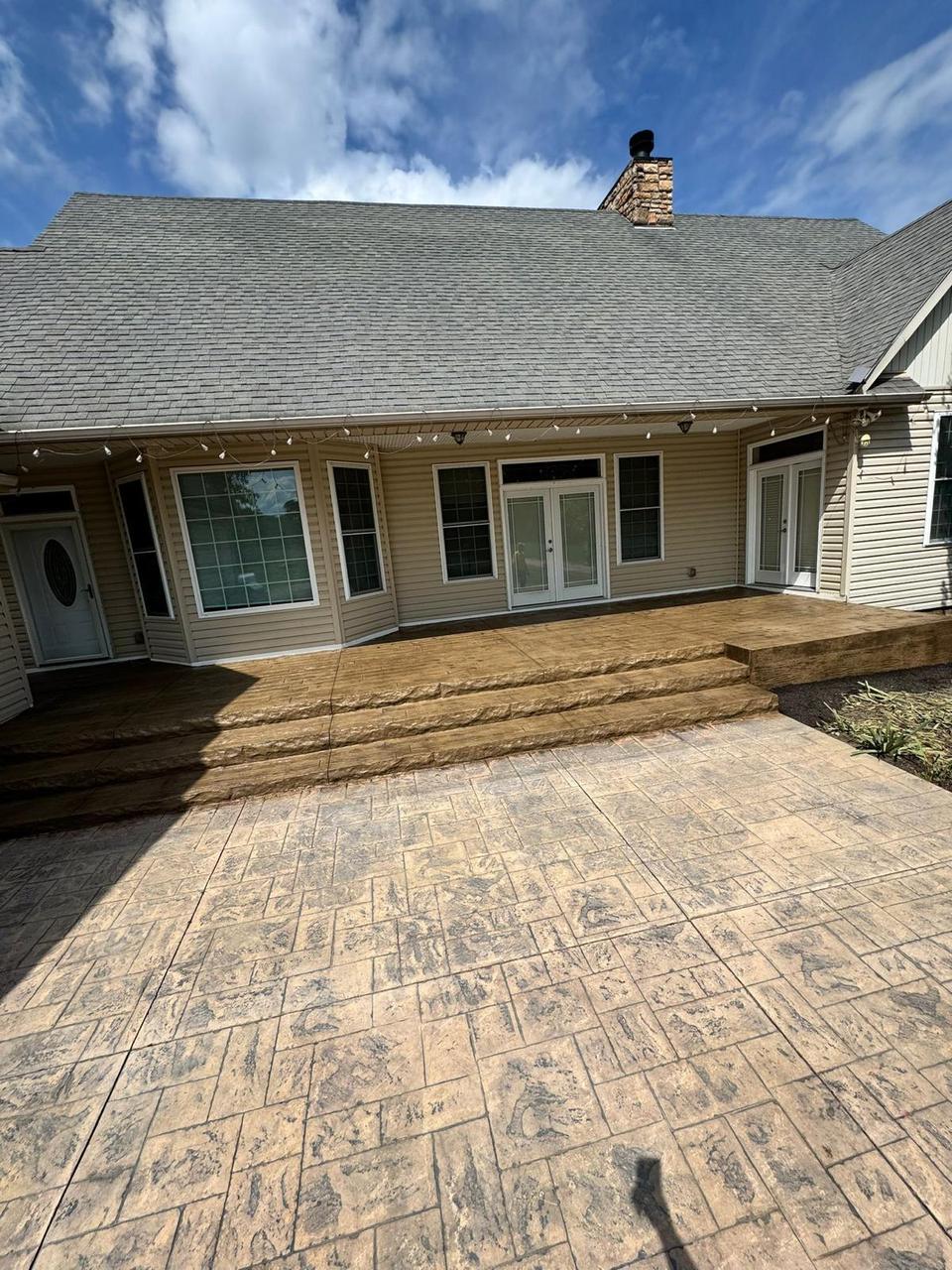 Tan ashlar stamped concrete patio with steps at a Columbus ranch home