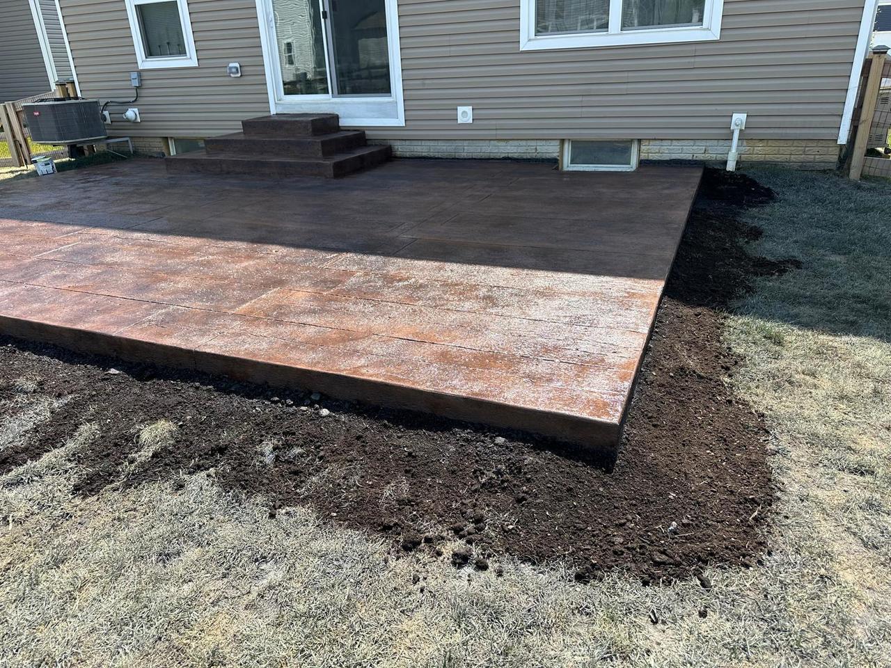 Wood plank stamped concrete patio with wide steps to the back door