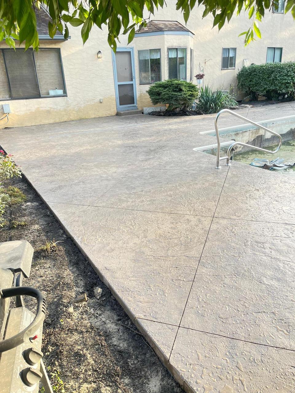Stamped concrete pool deck with stainless handrail