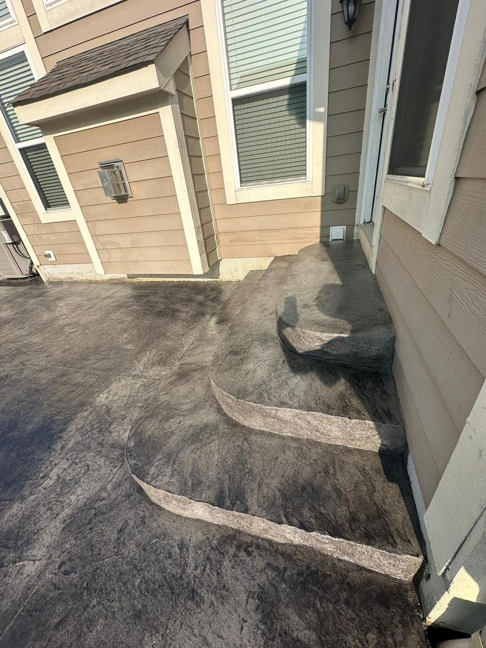 Curved stamped concrete steps with seamless stone texture at a back entry