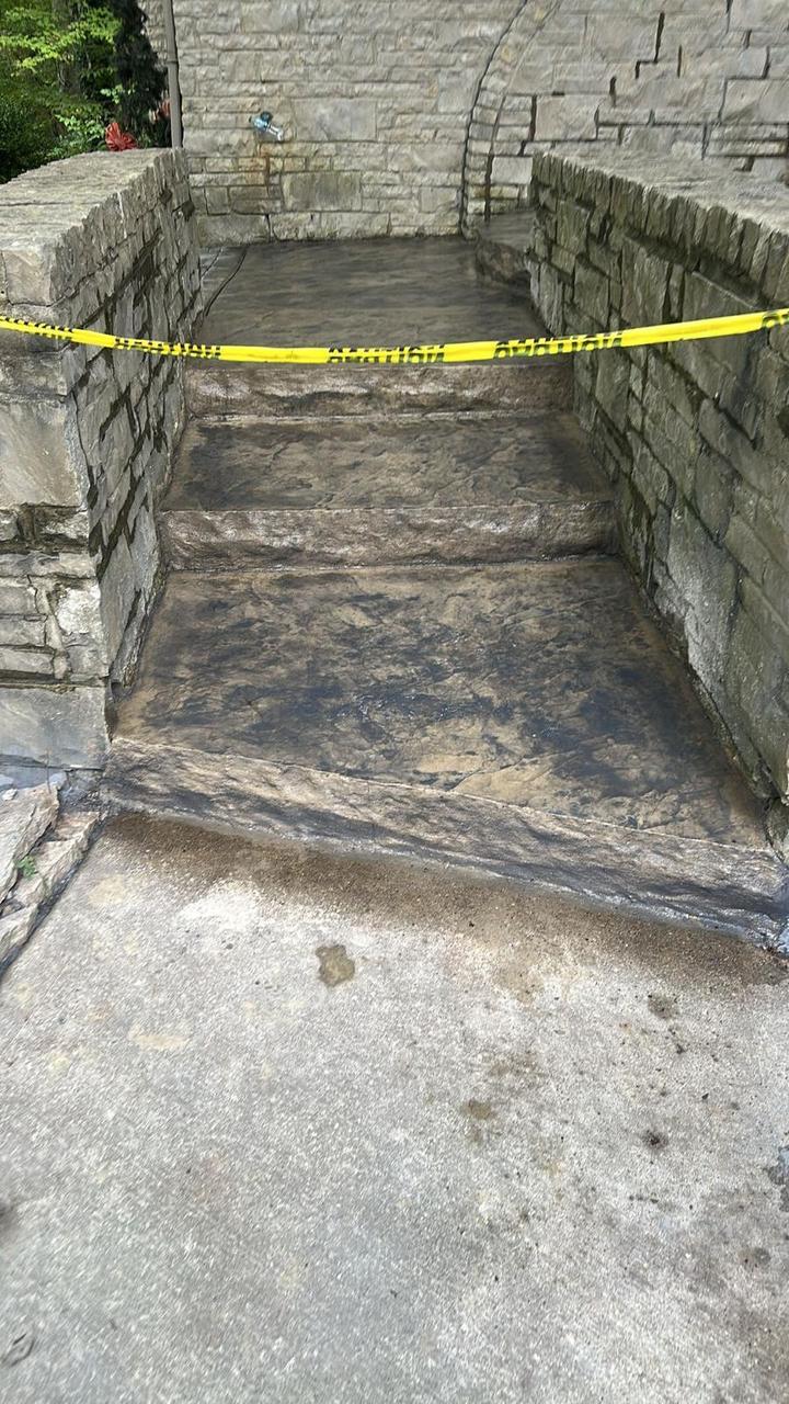 Stamped concrete steps between stone retaining walls